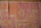 Short, even distressed pile of the Kurd runner in geometric pink, purple, and tangerine.
