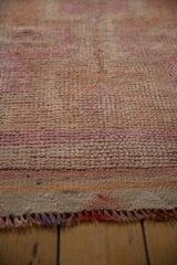 Distressed, hand-knotted vintage Kurd runner pile with muted pink and orange tones, fringed end.
