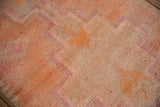 Distressed vintage Kurd runner close-up, showing pink zigzag and tangerine checkered pattern.