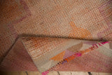 Folded distressed Kurd runner showing tight backing and vibrant pink, orange fringe.