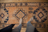 Distressed vintage Kurd runner texture, pale tangerine field, and navy geometric figures.