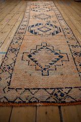 Textured distressed vintage Kurd runner with exposed knot heads and navy geometric patterns.