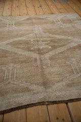Distressed Oushak rug pile with even wear, revealing faded medallion motifs in beige.
