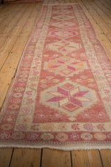 Distressed vintage Kurd runner, showing pinwheel blossoms and its meandering vine border.