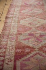 Distressed Kurd runner pile with even wear, faint foundation showing, geometric pale raspberry, ivory, fuchsia.