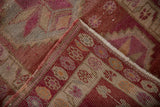 Distressed vintage Kurd runner's folded corner, showing geometric border, blossom motifs, and fringe.