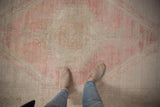 Vintage distressed Oushak rug displaying soft blush and platinum tones with even wear.