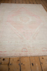Textured pile and faded blossom border of a vintage Oushak rug in blush and platinum tones.
