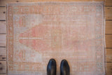 Overhead view showing the scale and distressed texture of a vintage Oushak prayer rug.