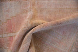 A folded view showing the even, low-pile wear on a distressed vintage Oushak rug.