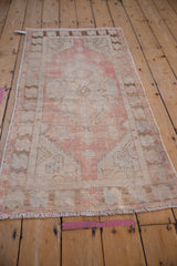 Distressed dusty rose central floral motif and shield medallion of vintage Oushak.