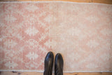 Time-softened texture and knot heads on a distressed Oushak rug in pale copper and ivory.
