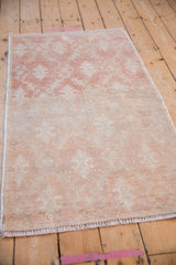 Angled view of a distressed Oushak rug showing its time-softened patina and low pile texture.