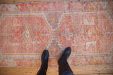 Tactile distressed texture of the Kurd runner with tangerine orange, ivory, and mauve geometric patterns.