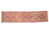 Vintage distressed Kurd runner with serrated geometric medallions in dusty red and ivory.