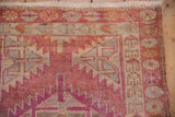 Distressed Kurd rug pile showing serrated geometric patterns, fringe, dusty red and beige tones.