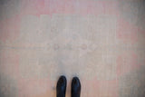 Evenly worn, low-pile texture of a distressed Oushak runner in faded pink and ivory hues.
