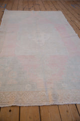 Low angle view of the distressed Oushak runner highlighting its even wear and rippled edge.
