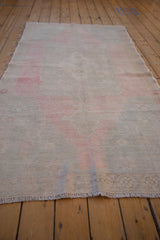 Low angle view down the length of the distressed Oushak runner, highlighting its soft wear and low-pile texture.