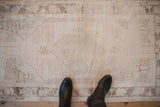 Top border and corner spandrel of the distressed Oushak rug with faded floral patterns.