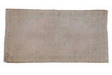 Vintage distressed Oushak runner with a faded medallion on a dusty mauve and beige abrashed field.
