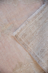 Back of a hand-knotted Turkish Oushak rug showing the woven foundation and secured edge.
