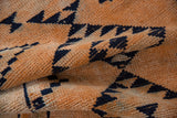 Distressed vintage Kurd runner with tangerine pile and primitive navy geometric gul motif.