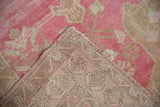 Distressed pink Oushak runner pile with original selvage and muted patterned knotted back.