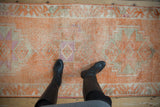 Textured pile of a distressed Kurd runner showcasing tangerine, ivory, and fuchsia abrash.
