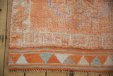 Distressed tangerine orange pile and geometric banded border with fringe on Kurd runner.