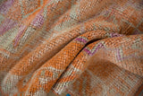 Lush, distressed Kurd rug pile showing tangerine orange, ivory, and fuchsia magenta.