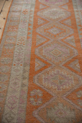 Distressed Kurd runner featuring tangerine orange serrated motifs and even pile wear.