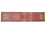 Distressed Kurd runner with geometric starbursts in cherry red, ivory, and dusty rose.