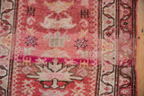 Distressed hand-knotted pile with starburst designs in cherry red, dusty rose, and ivory.
