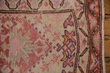 Corner view of a distressed Kurd runner showing the finned blossoms and abrashed ivory field.