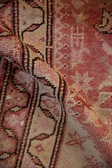 Soft fold on a distressed Kurd runner highlights its hand-knotted texture and vine border.