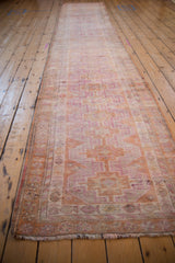 Distressed vintage Kurd runner, its geometric guls and hook motifs in fuchsia and tangerine.