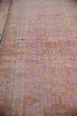 Distressed vintage Kurd runner pile, with fuchsia purple, tangerine geometric guls and even wear.