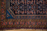 Vintage Hamadan rug corner, meandering vine border, cobalt Mahi-Mahi motif, tattered edge.