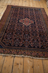 Tattered fringe and meandering vine floral main border on a vintage Hamadan rug.