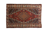 Vintage Hamadan rug with a geometric medallion, a cherry red field, and navy blue accents with floral details.