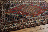 Layered borders with serrated leaves and geometric motifs on a vintage Hamadan rug.