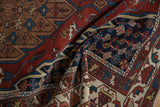 A draped vintage Hamadan rug revealing intricate patterns in its navy blue border and brown field.