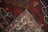 The folded corner of a vintage Hamadan rug reveals its hand-knotted wool foundation and construction.