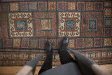 Kurdish runner's field of rust, blue, and ivory checkered boxes with rams horn motifs.