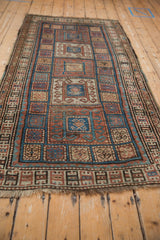 Antique Kurdish runner detail: checkered field with inverted coloration, scrolling rams horn motifs.