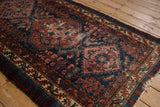 Vintage Mehreban rug's geometric medallion with cobalt blue and ruby red patterns, showing worn pile.