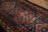 Vintage Fine Mehreban rug section, ruby red field with cobalt blue plant motifs, visible wear.