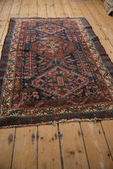 Vintage Mehreban rug's tattered fringe and geometric border in red, ivory, and teal.