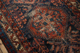 Close-up of vintage Mehreban rug's worn field, showing red, blue, and ivory tones.